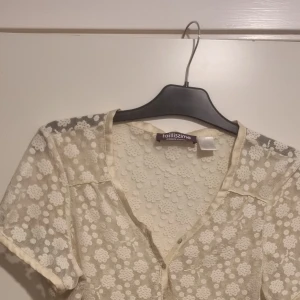 Blus - Cremefärgad blus med blommönster. Som ny. 