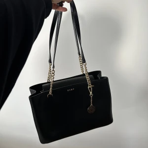 DKNY väska  - Använd en gång, nästan helt ny! Använt den en gång så väljer  att sälja den. 800kr. Medföljer (oanvänd) dustbag. 