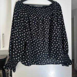Fin blus  - Svart blus med små söta blommor på i storlek 38  Plagget finns på fler sidor så kan säljas. 