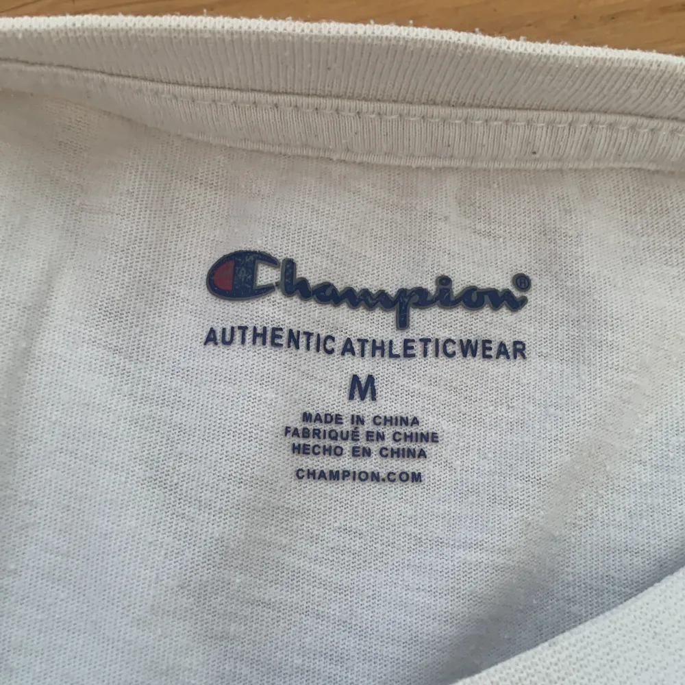 Den är vit med champion märket på framsidan. T-shirts.