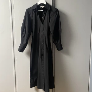 COS Skjortklänning med markerad midja & ballongärmar strl 34 (36)  - Superfin och stilren skjortklänning med markerad midja och ballongärmar. I strl 34 men är stor i storleken, passar även en liten 36a. I mycket bra skick! 