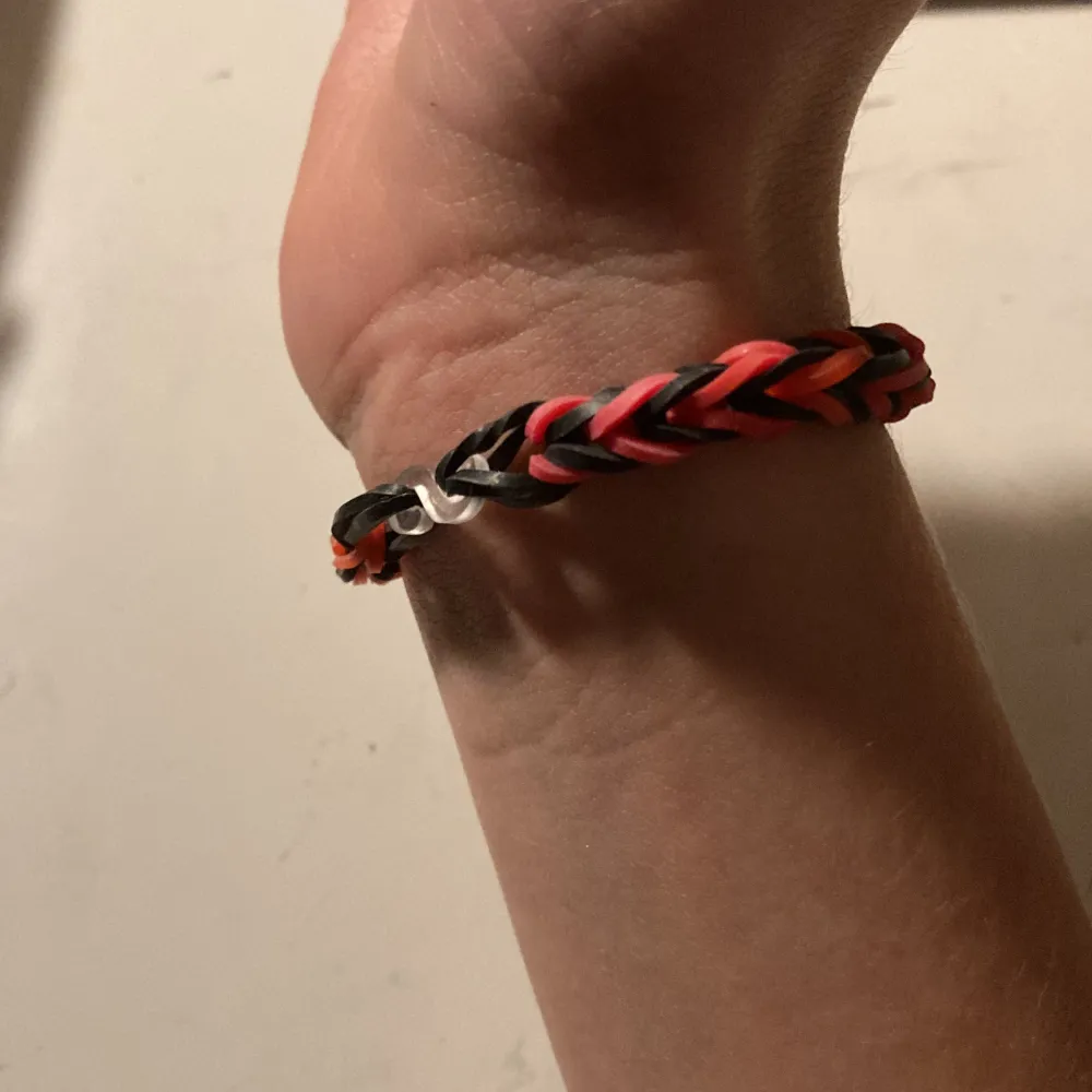 Svart/röd mönstrat armband av loombands, jag har gjort själv pris kan diskuteras, den passar alla för den kan stretchas jätte fin och fint skick. Asusteet.