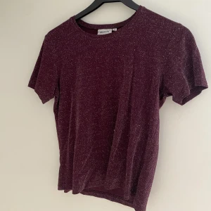 Glittrig tröja - Glittrig mörkröd/lila t-shirt. Använd fåtal gånger.