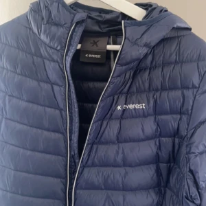 Marinblå jacka från everest - Marinblå dunjacka från Everest. Storlek 46 men liten i storlek. Sitter oversized på mig som har 38. Köpt för 999 men säljer nu för 550 eller bud!
