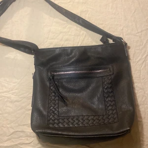 Svart axelväska - Röd på insidan, bandet går att göra längre och kortare, en ficka på sidan. Priset kan diskuteras:)