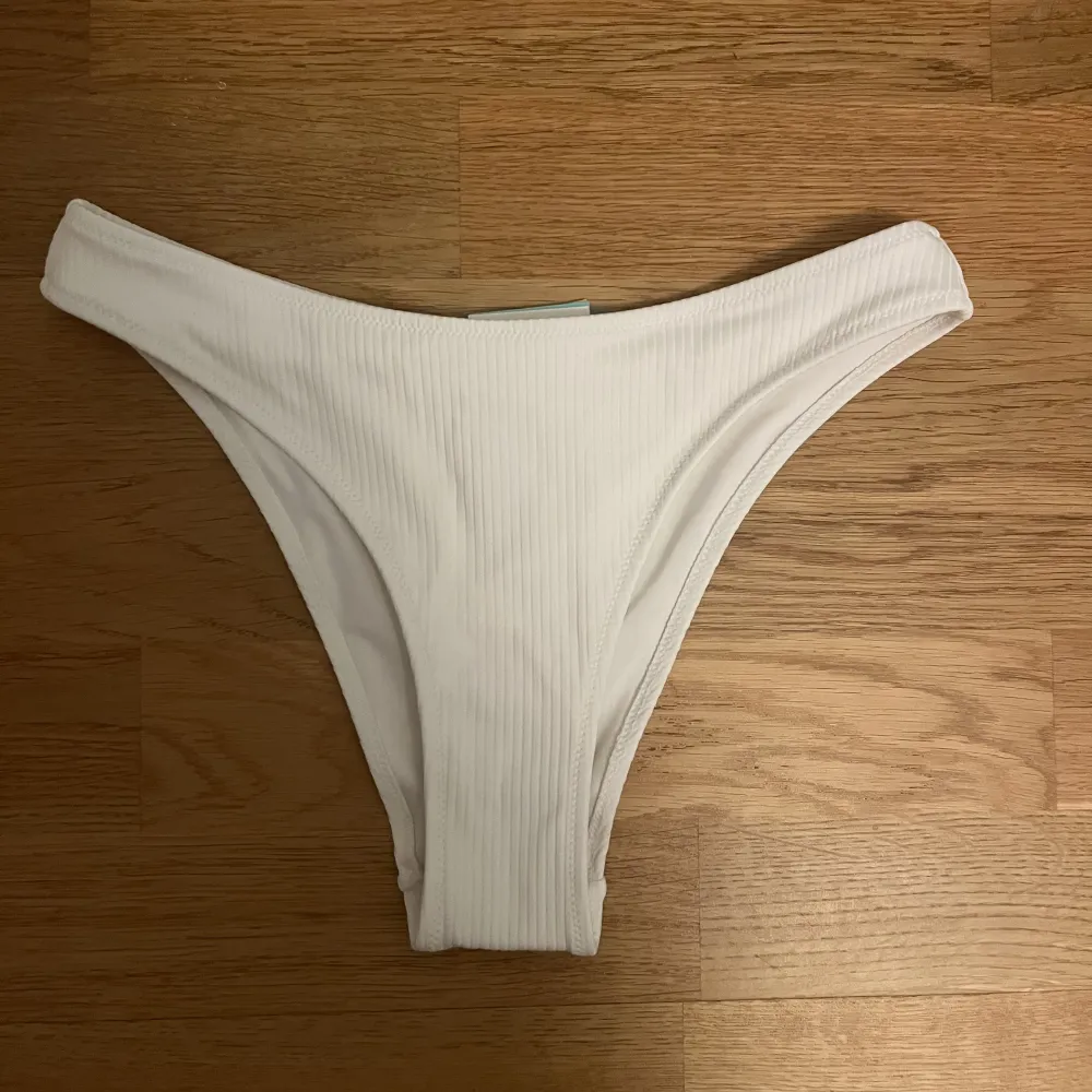 Säljer denna vita bikiniunderdelen från H&M då den är för stor för mig! Prislappen och skyddet sitter kvar och den är endast testad en gång med dubbelt skydd så i princip oanvänd!. Shorts.