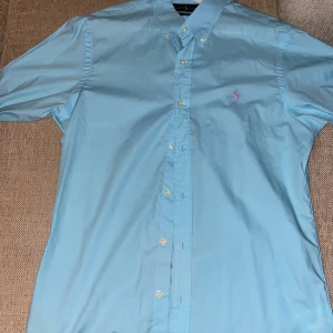 Ralph Lauren Skjorta  - Slimfit. Turkosblå. Poplin tyg (mjuk och skön) storlek M. Aldrig använt pga fel storlek. Kan byta mot storlek L ( måste va poplin tyg)