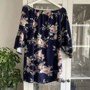 En kort blommig klänning, skönt material sparsamt använd 