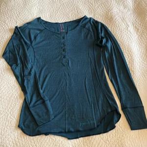 Houdini Light Base merino/silke - Snygg o tunn underställströja från Houdini i 75% merinoull och 25% silke. Snygga detaljer som knapparna i halseingningen. Som ny