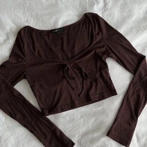 Brun topp - Söt liten brun långärmad topp. Lätt urringning, sitter tight. 