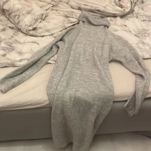 Lång stickad klönning - Säljer en lång grå stickad klänning, använd typ 3-4 gånger. Väldigt varmt och skönt material. 