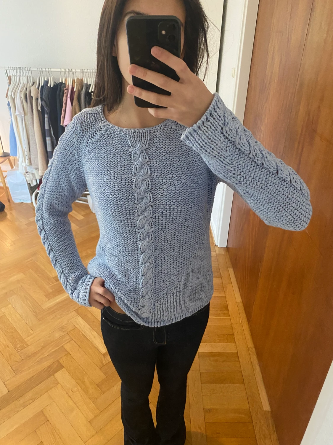 Lös stickad ljus blå tröja med flätor på armarna och i mitten partiet