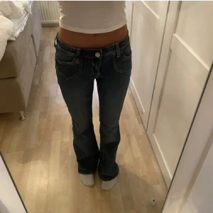 Lågmidjade jeans  - Säljer dessa blåa lågmidjade jeansen då de är för stora för mig. Jag har gjort två små hål inuti och trätt igenom ett snöre eftersom de är för stora i midjan, men det är ingenting som syns på utsidan. (se bild 3) midjemåttet: 74cm - innerbenslängden: 75cm