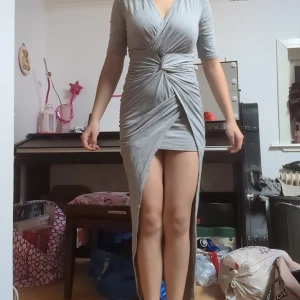 Klänning - En grå kort klänning med nå form av längre slits. Har gått upp ett hål i ryggen men går att sy ihop. Hittar ingen storlek men passar xs/s.