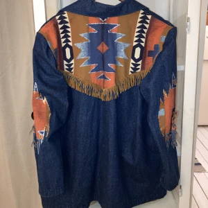 Jeansjacka western cowboy fransar  - Så JÄVLA ball jeansjacka med fransar på ryggen och detaljer på armarna. Oversized så passar XS-l. Den är mycket mycket snyggare i verkligheten!