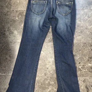 Y2k jeans - Hej säljer de här fina y2k jeansen, dragkedjan har gått sönder därför sydde jag ihop den istället💕 skriv för fler bilder!