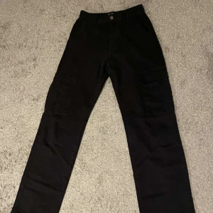 Cargo Pants - Hög midjade byxor. Rak passform. Funktionella fickor. Sitter bra och är sköna att gå i. Använts 2 gånger. Köpta för 369kr.