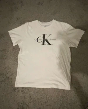 Calvin Klein T-shirt  - T- shirt med print. Använts 4 gånger. Inga fläckar eller märken.