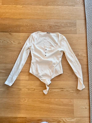 Body med knappar  - En super fin body från NAKD X PAMELA, köptes för några år sen och används inte idag💞