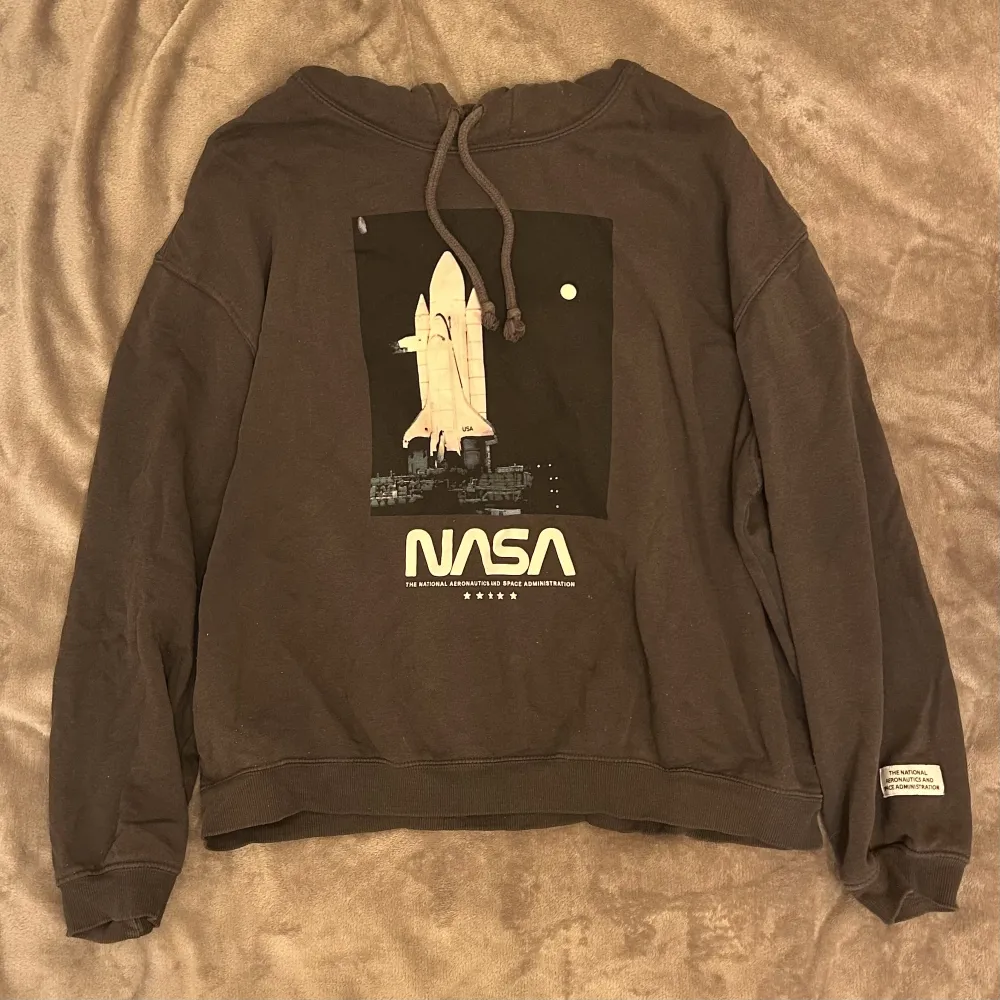 Grå snygg NASA hoodie från H&M. Väl använd men i gott skick. Oversized i modellen så passar fler storlekar. . Hoodies.
