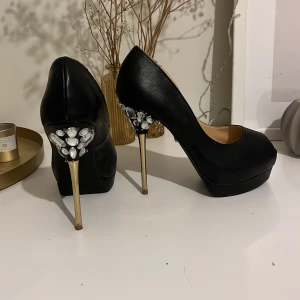 Höga stilettklackar - Svinsnygga stilettklackar med strass baktill. Höjd 11-12cm. Öppen tå. Använda 3 gånger, i gott skick! 