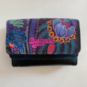 En färgglad plånbok med utrymme för både kort, kontanter samt mynt.