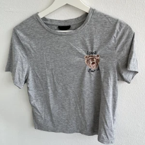 Grå croptop med broderi - Smått nopprig, broderi av Björn som skapar väck i tröjan