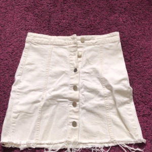 Vit jeanskjol  - Vit jeanskjol med fransar längst ner, med knappöppning från Gina! Lite fläckar här och var, kan försöka få bort 🩵priv 🩵 superskön, lagom längd 💞säljer pga för stor, pris diskuterbart 