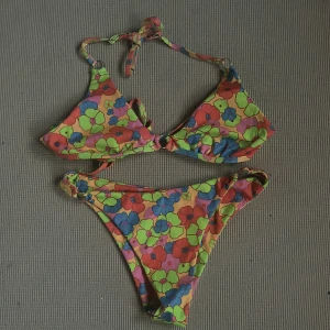 Bikini set 👙 - Orange bikini set med neon färgade blommor. Man kan själv spänna in banden hur man vill ha dem. Enadast använd 1-2 gånger (KÖPAREN STÅR FÖR FRAKTEN!)