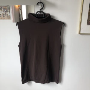 Linne med polokrage - Brunt linne med polokrage i stretchigt material. Skulle gissa på storlek XS/S🤎
