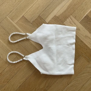 Vit topp - Säljer min super fina vita topp med pärl-band från berscka då den tyvärr inte används längre, den är imprincip oanvänd och är verkligen en perfekt fest topp med ocksp vardags topp