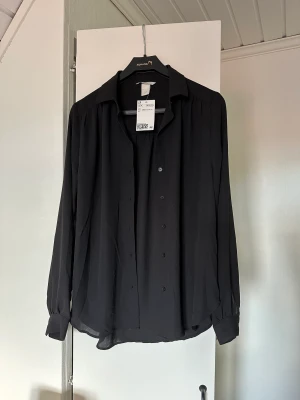 Svart skjorta 🖤 - Svart skjorta från h&m🖤Aldrig använd, prislappen sitter kvar. Nypris 149 men säljer för 50 :) storlek 34 men skulle säga att den är mer som 36