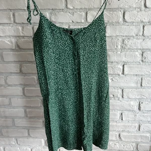 & Other stories- Grön prickig klänning  - Grön klänning med vita prickar och knappar från & Other stories. Perfekt till sommar och strand. 