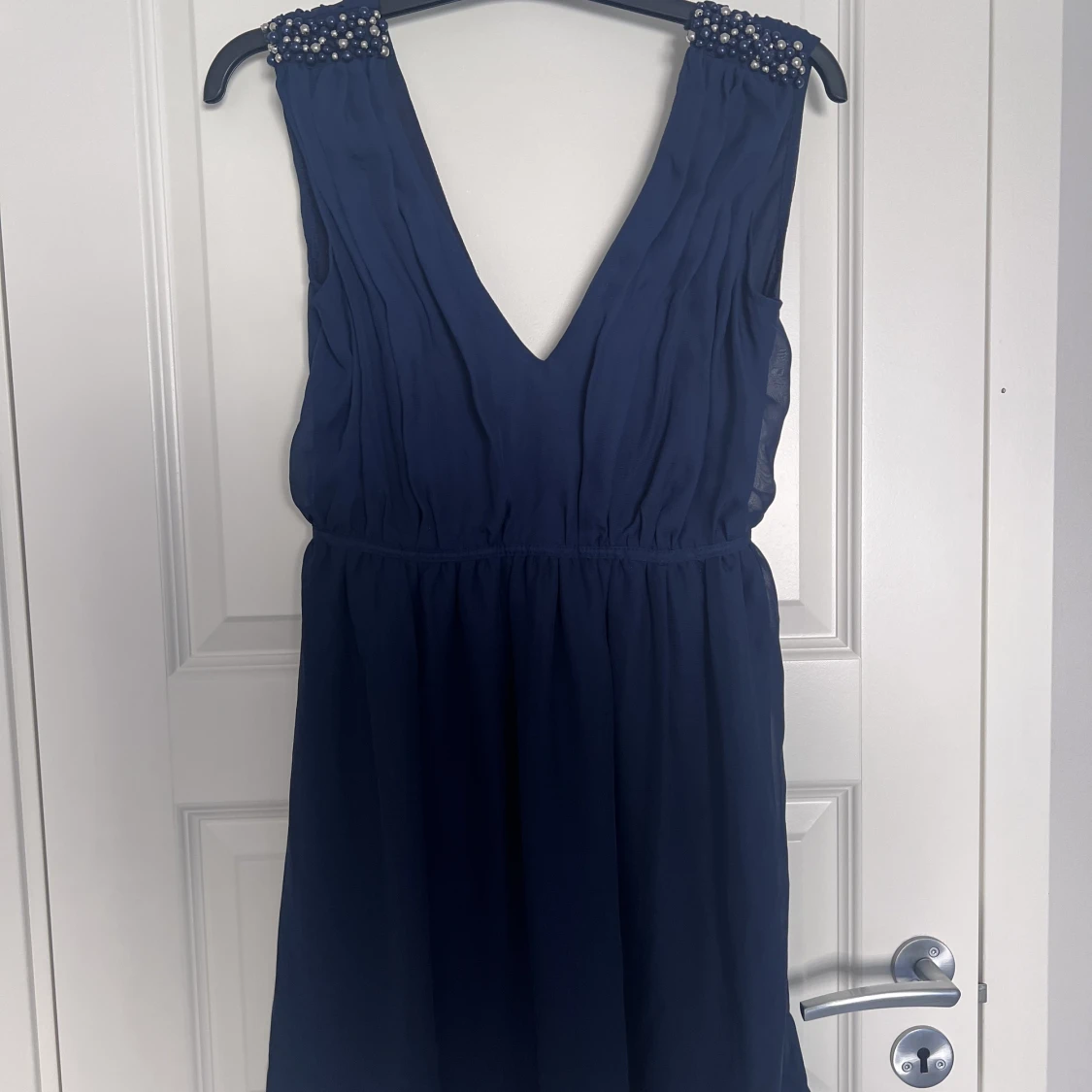 Festklänning till knän med pärlor på axlarna 