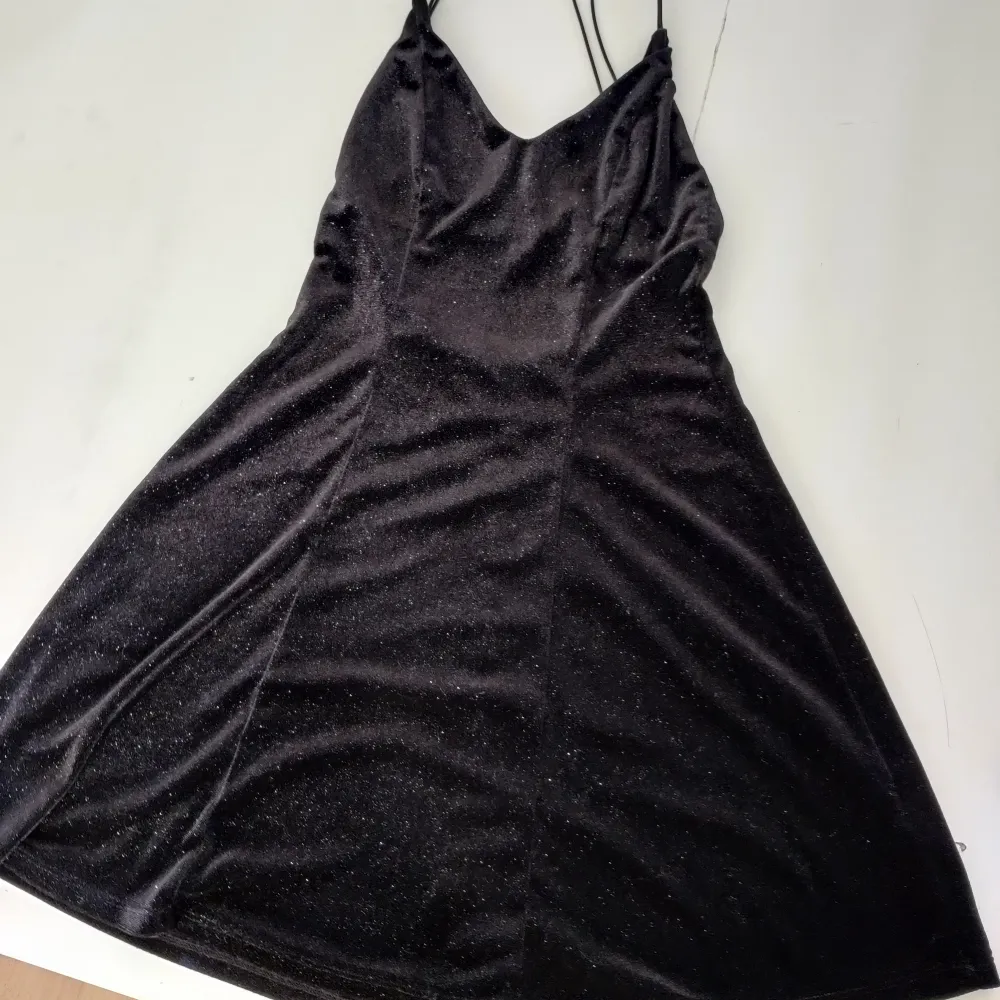 Black stretchy dress with silver glitter specs, waist suited for 60 to 85 cm. Length of the dress is 85 cm. Klänningar.