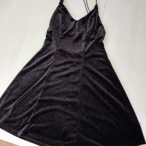 Black stretchy dress with silver glitter specs, waist suited for 60 to 85 cm. Length of the dress is 85 cm