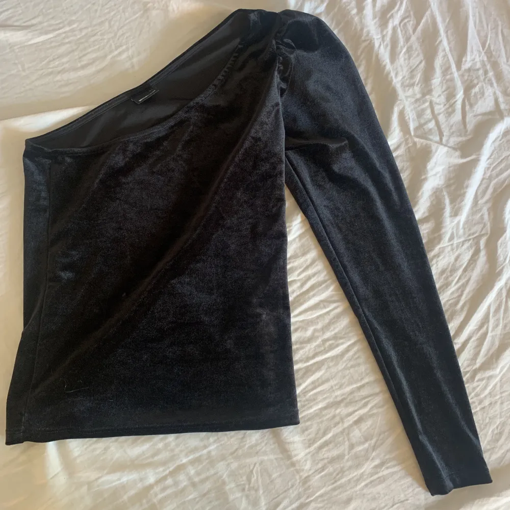 jag säljer denna snygga enarmade svarta tröjan i sammet från Gina då den inte kommer till användning längre! Använd fåtal gånger 💕💕(passar även någon som har S). Toppar.