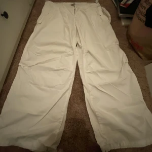 Byxor - Större vita byxor som har elastiskt midjeband vilket man kan justera längden på. Tyvärr har den en trasig knapp på den vänstra sidan‼️ Använd helst köp nu!