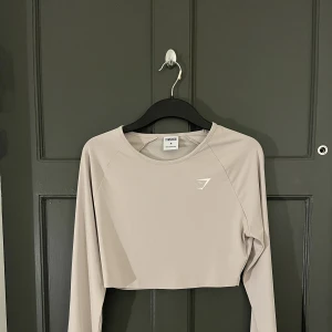 Gymshark långärmad topp - Gymshark ”Training Long Sleeve Crop Top - Grey (beige)” i storlek Medium. Använda ca två gånger. Nypris 249kr