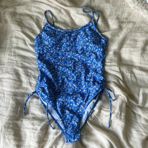 Baddräkt  - Blå baddräkt med vita blommor, använd 1 gång!