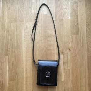Svart väska i läder - Svart liten vintage väska i läder. Jättefin! Köpt på second hand och använd fåtal gånger. 