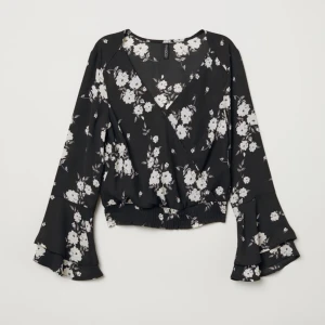 Blommig omlottopp  - Blommig omlottopp från H&M i storlek 32. Tunt material och knäppning i urringningen. Aldrig använd, nyskick.