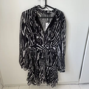 Ny ZARA klänning - Helt oanvänd klänning från ZARA. Storlek M. Mesh tyg i svart/vitt, klänningen slutar vid låren. Väldigt fin nu till sommaren. V ringad.