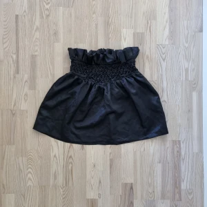 Kjol - Fin kjol i satin med dragkedja baktill.  Fin skick snålt använd