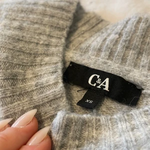 Grå Sthlm stil tröja  - En fin stickad grå tröja som säljs för inte har användning av den längre och använd få gånger.