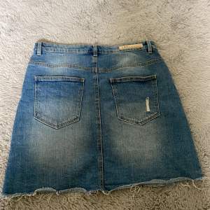 Jeans kjol som är i nyskick, endast använd 1 gång! Går att spänna in vid midjan. Midjemåttet är 36 från sida till sida.