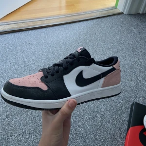 Jordan 1 low storlek 43 - Jordan 1 low i storlek 43. Använda men i bra skick. Rosa extrasnören hänger med. Lite små smutsiga men går nog enkelt att tvätta bort.