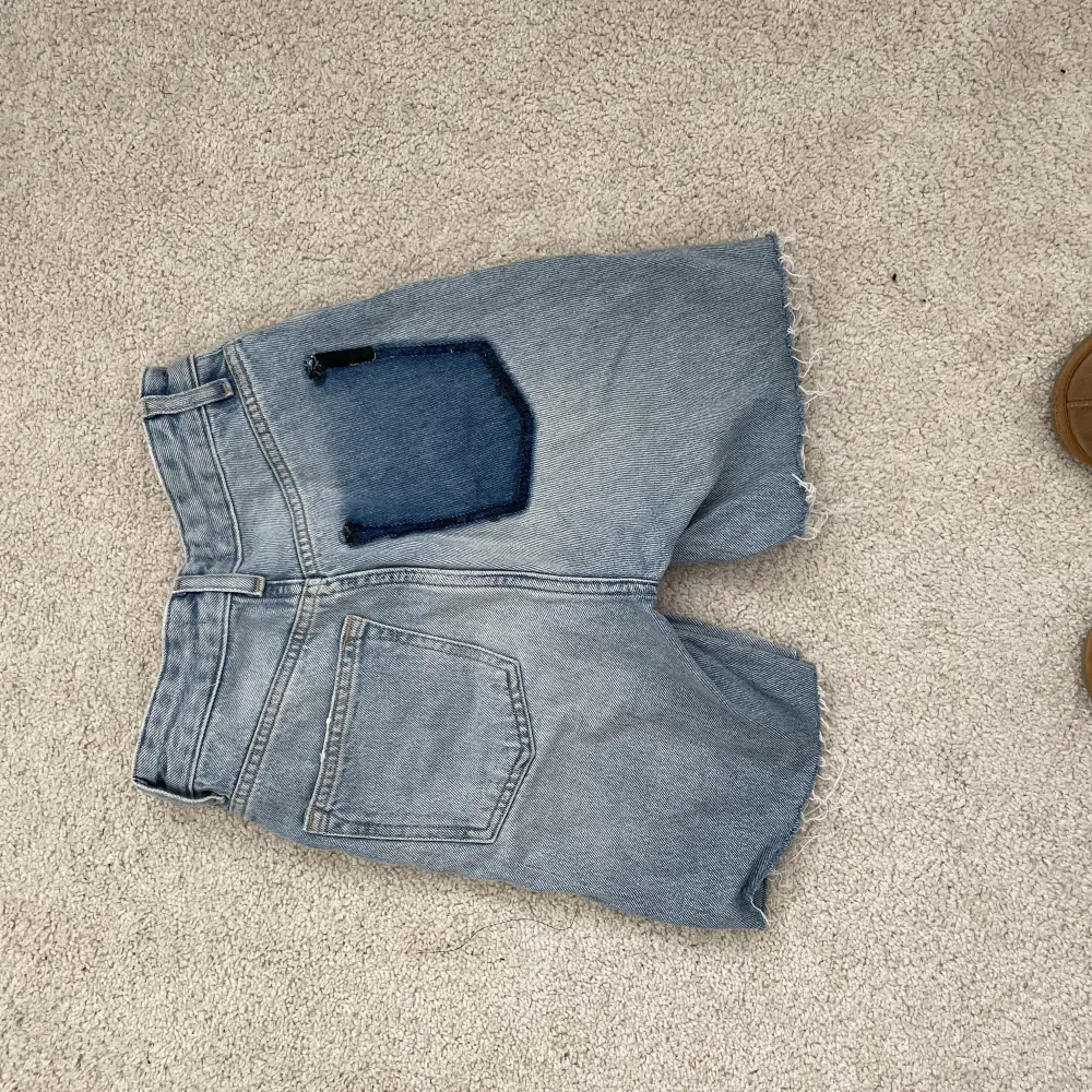Blå jeans shorts som från grunden är ett par jeans från HM. Har sedan innan suttit ett tryck på benet som är borttaget (därpå ”fläcken”)   Högmidjade !   50kr (står inte för frakten) . Shorts.
