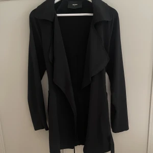 Kappa  - En svart kappa köpt på Bikbok. Kappan är tunn i materialet. 