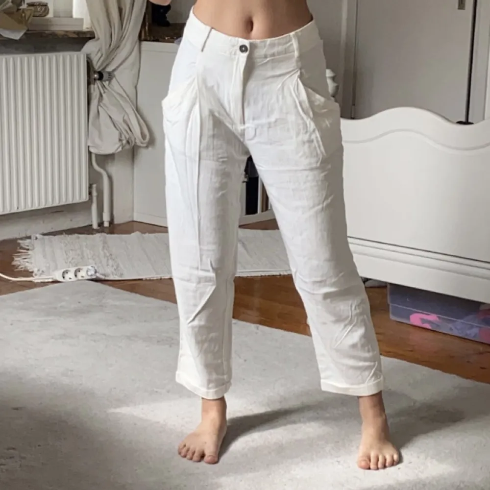 Vita ankellånga byxor från Zara i storlek S. Löst och flowigt material med två fickor fram och två fake fickor bak. Lösa i passformen och snygg modell. Innerbenslängd: Ca 60 cm. Jeans & Byxor.